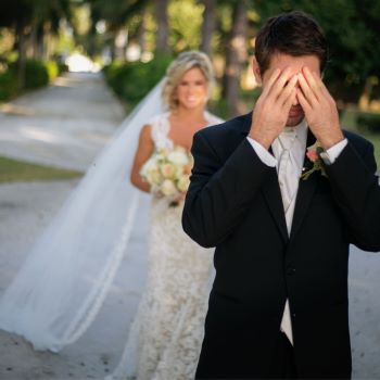 Groom
covering his eyes with his hands as bride
approaches from behind