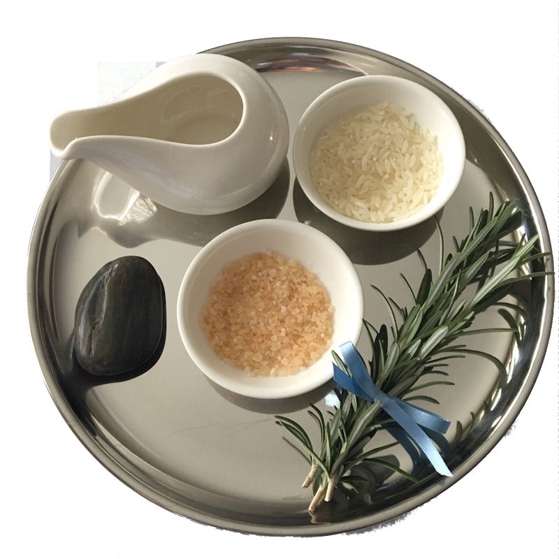 Fruits of the Earth Ritual. Silver Tray
containing white water jug, black pebble, white
dishes containing rice and salt, and a sprig of
rosemary tied with a blue ribbon